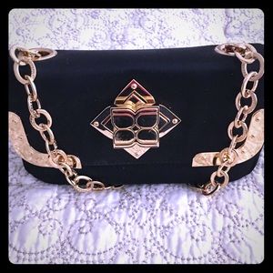 BCBG black clutch with gold hardware details.
